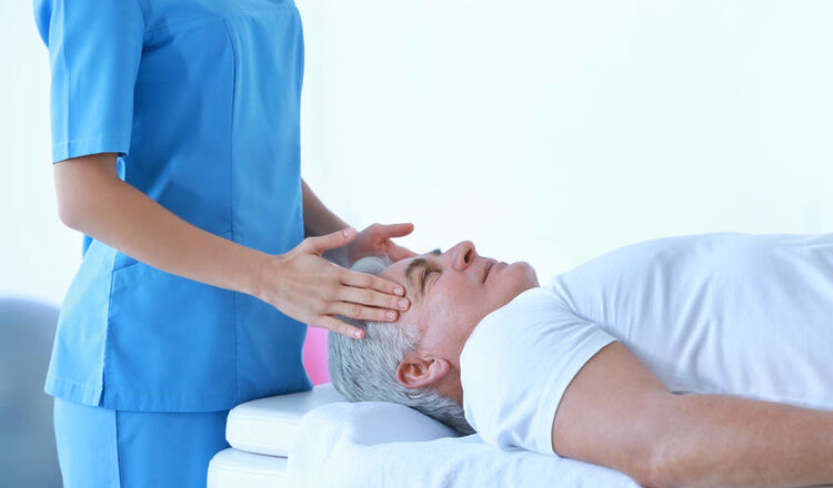 Fizjoterapeutka masuje głowę pacjentowi